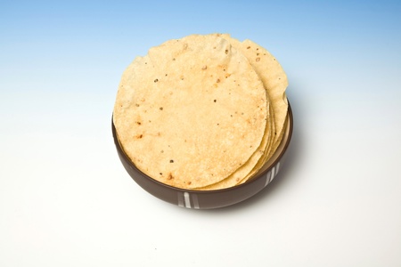 bowl of Pappadums on a blue studio background.の写真素材
