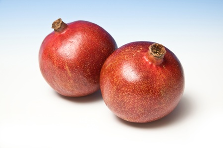 Pomegranetes on a blue studio background.の写真素材
