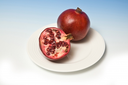 Pomegranetes on a blue studio background.の写真素材