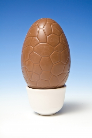 Chocolate Easter egg on a blue studio background.の写真素材
