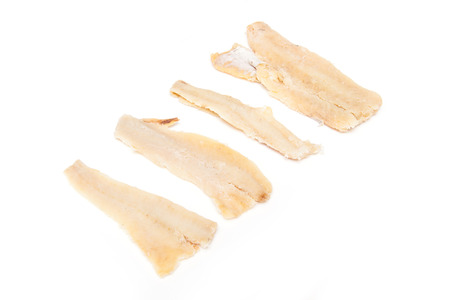 Pieces of salt cod fish isolated on a white studio background.