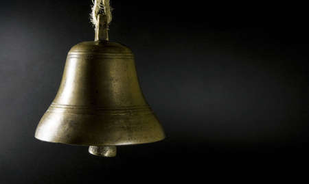 Old bell against black backgroundの写真素材