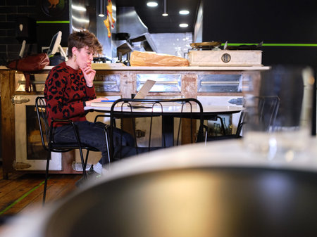 Worried woman working in the management of a restaurant with a laptop