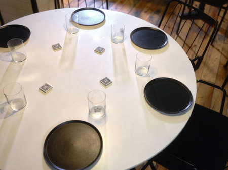 Round table prepared for six people in a restaurantの写真素材