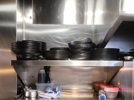 Restaurant with metal shelving with stacked dishes ready for kitchen service