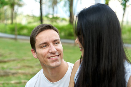 Man staring at his partner while sitting in a park