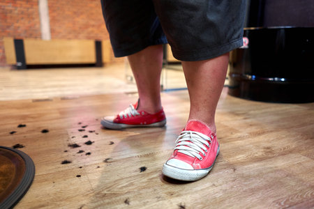 Barbers feet surrounded by hair on the floor