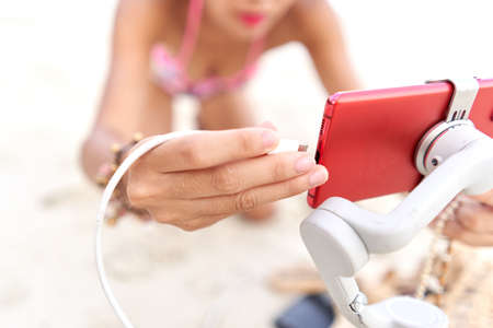 Streamer connecting the battery to the mobile to make a live broadcast outdoorsの写真素材