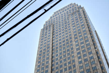 Electric wire crossing the sky next to a skyscraper in Bangkok