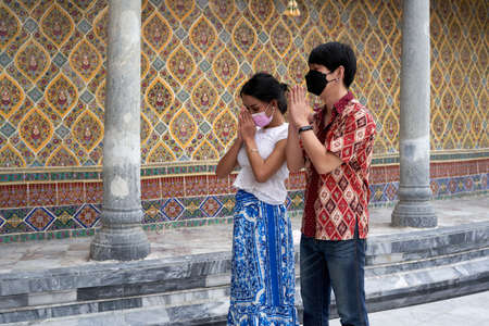 Transsexual couple praying in a buddhist templeの写真素材