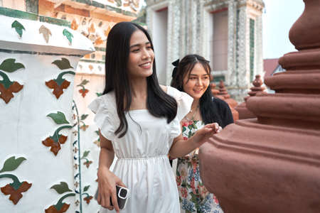 Two asian women visiting an ancient buddhist templeの写真素材