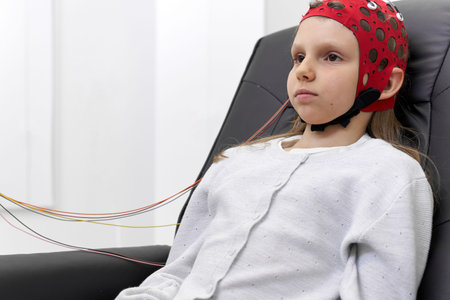 Girl sitting with serious expression during a biofeedback session in a clinic