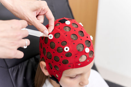 Doctor applying a liquid to a patients headgear for biofeedback therapy