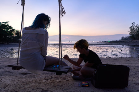 Silhouette of an artist during a body paint session on the beach