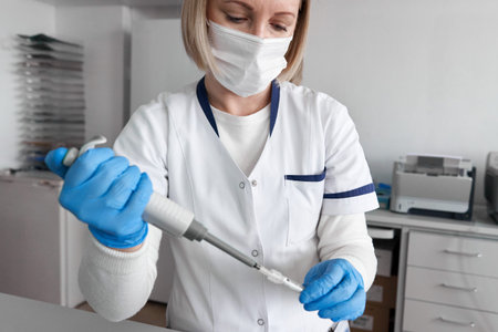 Worker of a laboratory of an hospital working with samples with a pipette