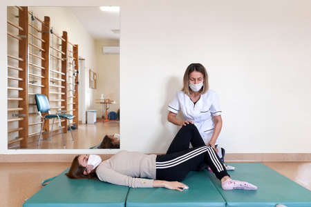 Physiotherapist doing rehabilitation exercises on a patient