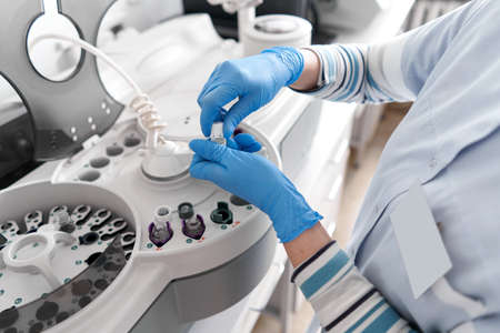 Laboratory technician working with a centrifuge machineの写真素材