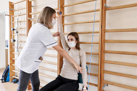 Physiotherapist working with a patient in a rehabilitation roomの写真素材