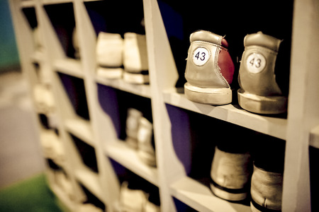 Shoe cupboard by the bowling alley, old  bowling shoes put in order, visible shoe sizes, numerous pairs of shoes, shallow DOF の写真素材