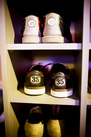 Old  bowling shoes placed in the cupboard, visible shoe sizes, fragment of wardrobe, vertical frame の写真素材