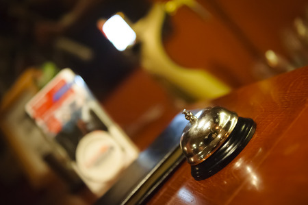 Silver metallic bell on the brown in the hotel  reception or restaurant, shallow DOF の写真素材
