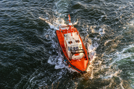 Orange and white coast guard lifeboard photographed from bird