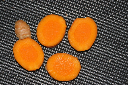 Section of rhizome of Yellow Turmeric, Curcuma longa, orange yellow inside, dried powder used in curries, medicinal and coloring material.の写真素材