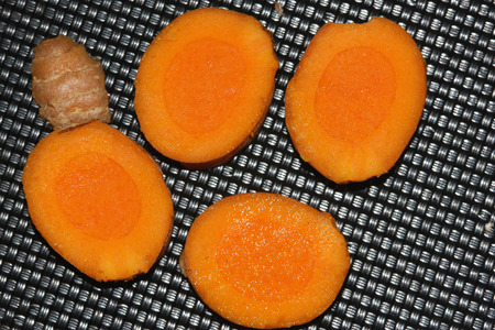 Section of rhizome of Yellow Turmeric, Curcuma longa, orange yellow inside, dried powder used in curries, medicinal and coloring material.の写真素材
