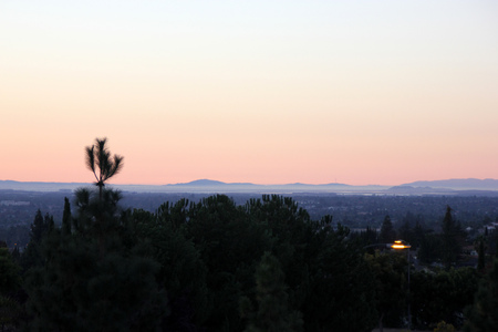 Sunset view of San Jose city, California from near Sikh Gurdwara on hill, with golden sky and haze just above the horizon.の写真素材