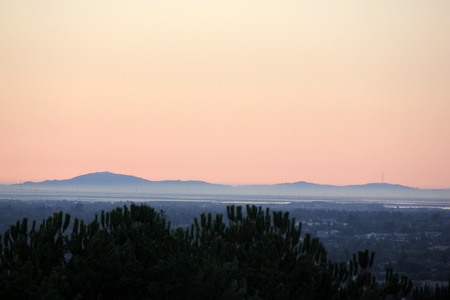 Sunset view of San Jose city, California from near Sikh Gurdwara on hill, with golden sky and haze just above the horizon.の写真素材