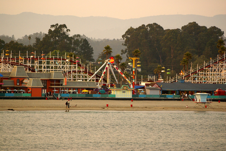 Santa Cruz Bay area in California, USA, thronged by visitors with parked boats and ships, majestic buildings, rows of palms and play areas.のeditorial素材