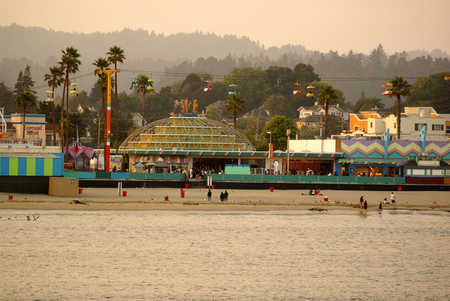 Santa Cruz Bay area in California, USA, thronged by visitors with parked boats and ships, majestic buildings, rows of palms and play areas.のeditorial素材