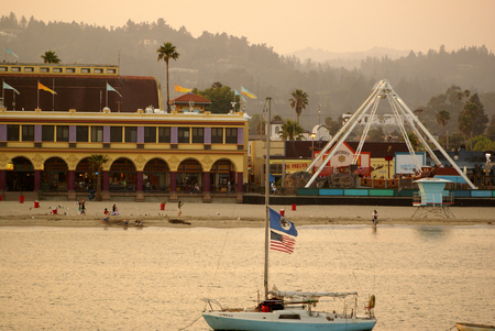 Santa Cruz Bay area in California, USA, thronged by visitors with parked boats and ships, majestic buildings, rows of palms and play areas.のeditorial素材