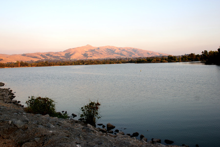 Evening view of Lake Elizabeth, Central Park, Fremont, California, USA, scenic lake with a pedway around it and panormic view of Mission Peak hills, popular spot for picnics, games and waterpark.の写真素材