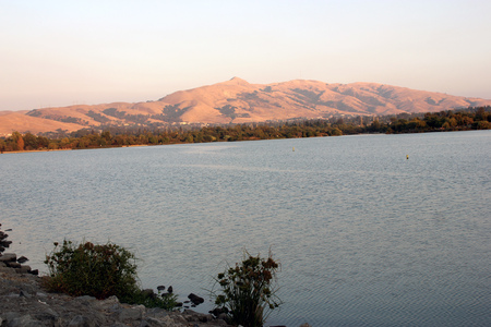Evening view of Lake Elizabeth, Central Park, Fremont, California, USA, scenic lake with a pedway around it and panormic view of Mission Peak hills, popular spot for picnics, games and waterpark.の写真素材