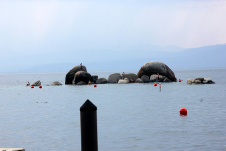 Sand harbor, Tahoe Lake on Nevada side, a popular destination for water activities, with huge rocks deep inside lake popular jumping platform for swimmers.のeditorial素材