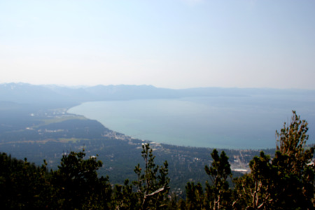View of Lake Tahoe, buildings and shoreline from upper deck of Heavenly Gondola, providing panoramic view of low isolated clouds and distant mountain ranges.の写真素材