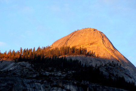 Sunset on North Dome, Yosemite, view from Curry Village Parking, intense orange Yellow color rays at 16.47, November 24, on upper half of the dome slowly changing to orange and finally redのeditorial素材
