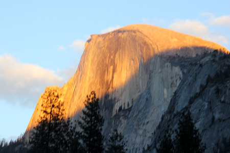 Sunset on Half Dome, Yosemite, view from Curry Village Parking,  orange yellow color rays at 16.45, November 24, on upper half of the dome slowly changing to finally redのeditorial素材