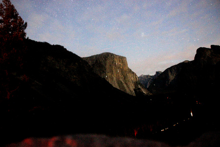 Early night view of peaks from Tunnel view, Yosemite National Park, California, with traffic lights, camping sites and mountaineers climbing on rocks mainly El Capitan on left.の写真素材