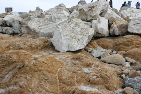 Visitors on boulders and rocks on shores of Bird Rock, Pebble Beach, 17 Mile Drive, California, USA, popular visitor destination, mid sea huge rock with numerous birds, sea otters and sea lions.の写真素材