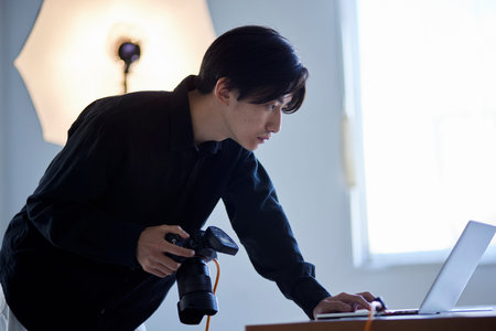 Japan photographer man operating laptop in photo studio