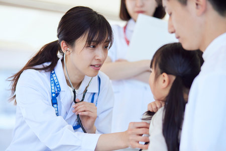 Female doctor examining a child in a hospital examination roomの写真素材
