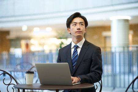 Japan businessman in suit working remotely using laptopの写真素材