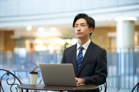 Japan businessman in suit working remotely using laptopの写真素材