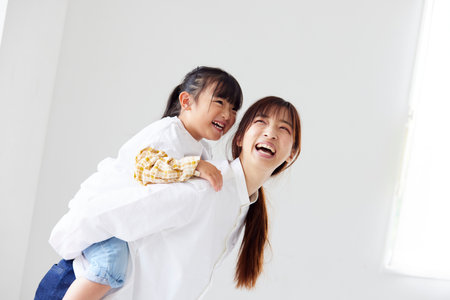 Happy Japan mother and child playing in the living roomの写真素材