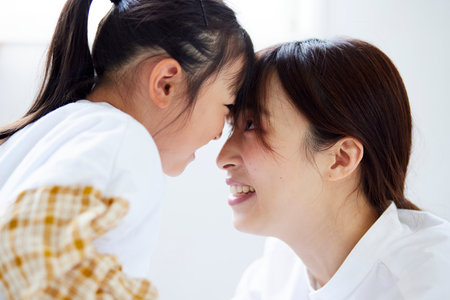 Happy Japan mother and child facing each other in the living roomの写真素材