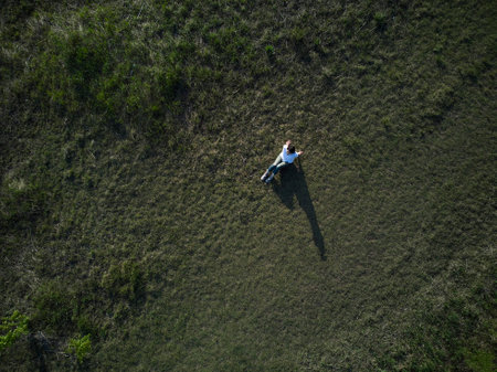 Summer image of a Japan woman lying down and relaxing in a forest rich in natureの写真素材
