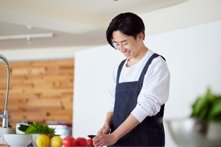 Young Japan man cooking in kitchenの写真素材