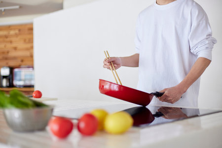 Young Japan man cooking in kitchenの写真素材